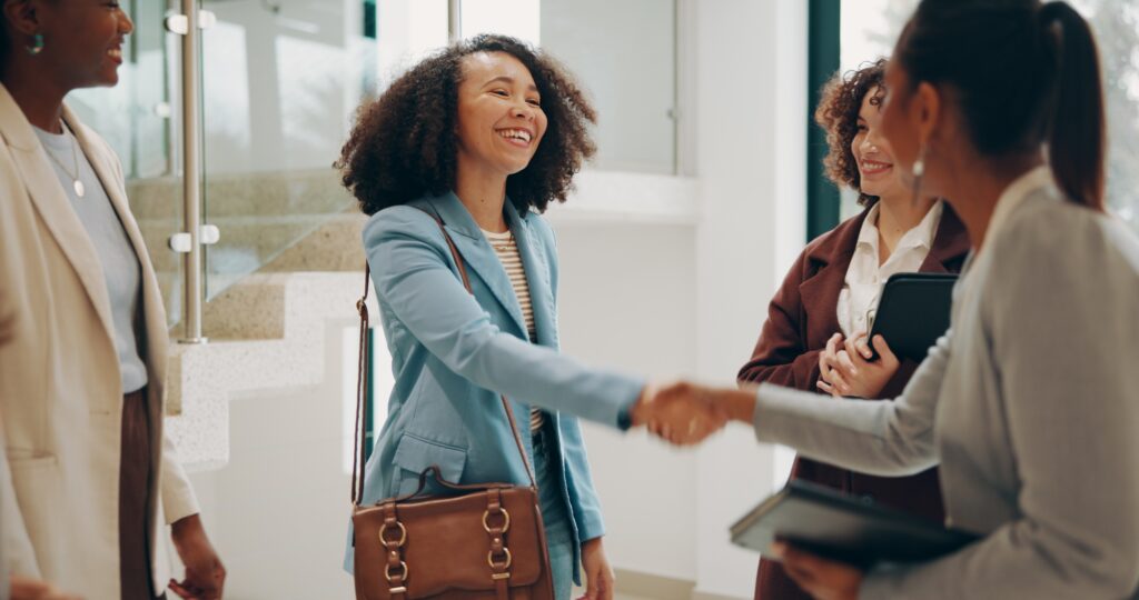 Business, women and excited at office with handshake for recruitment, welcome and agreement. People
